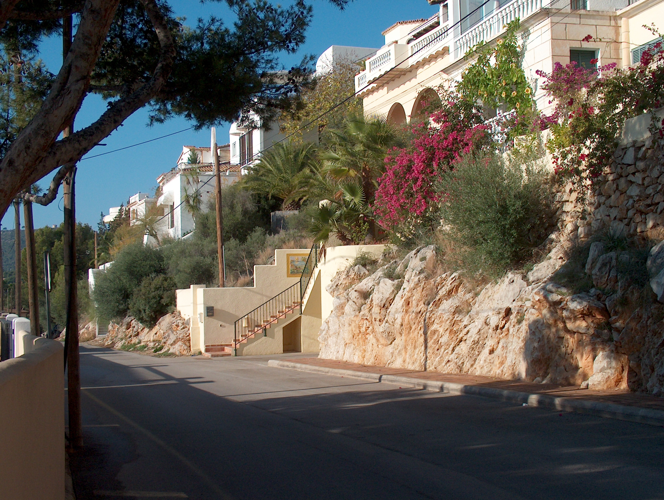 Cala Fornells (Mallorca): helder cove-resort bij Peguera 7 Een straatje in Cala Fornells dat tussen de rotswand en de witte en okerkleurige huizen met bloeiende bougainville naar beneden loopt