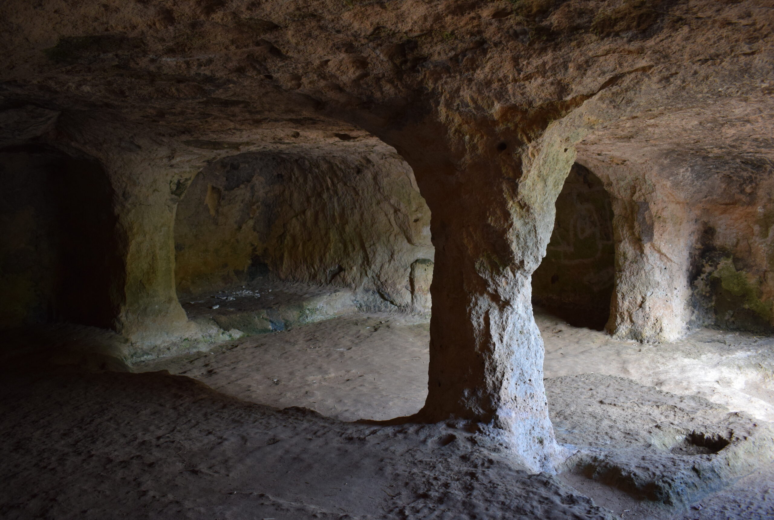 Cala Morell Menorca: witte huizen, grafgrotten en een klein rotsstrand 8 Het interieur van grot 4 van de necropolis van Cala Morell met de uitgehakte centrale zuil
