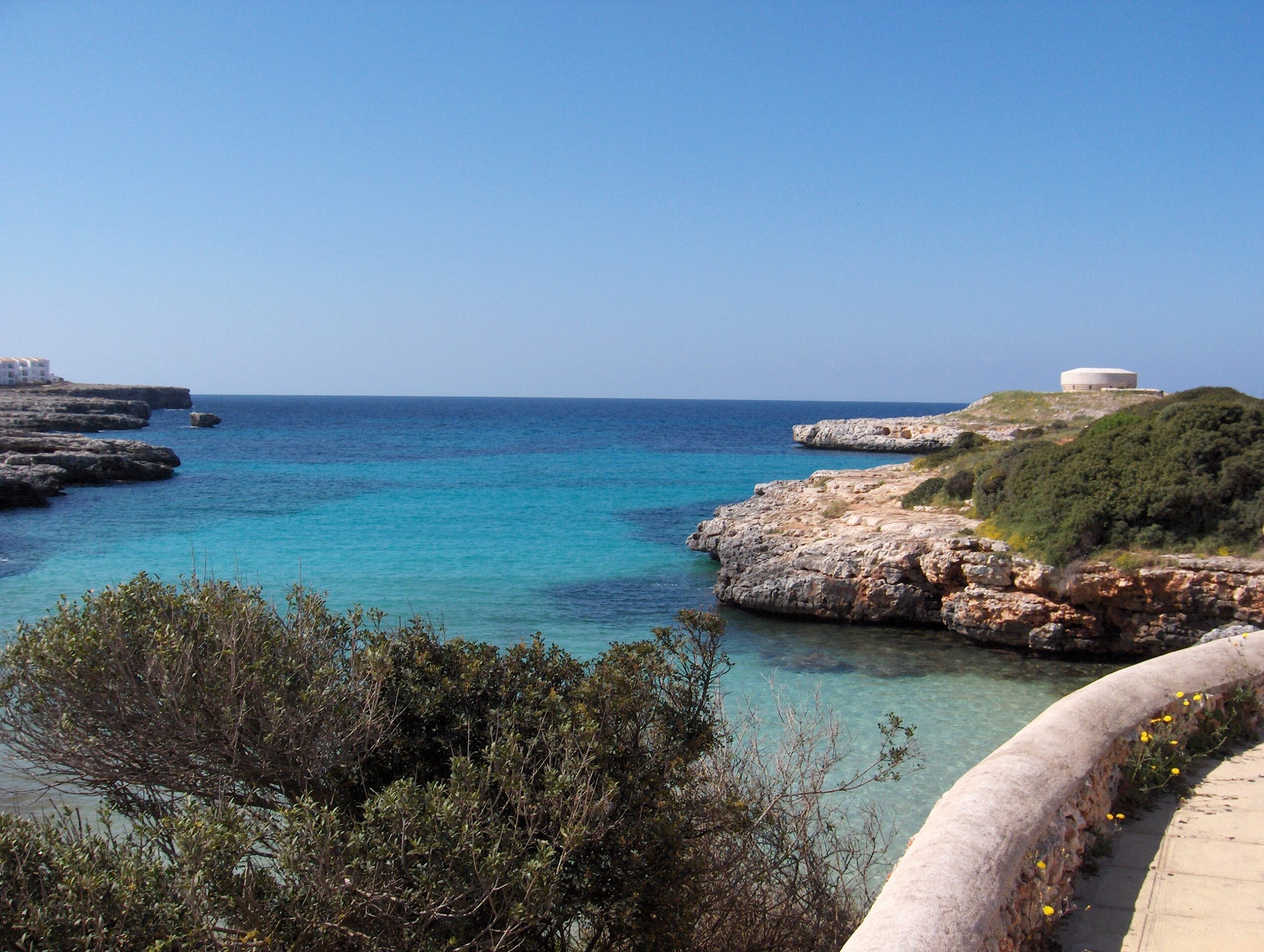 Cala Santandría Menorca: de beschutte kreek bij Ciutadella en de Torre des Castellar 6 Het heldere water van het naburige Sa Caleta met de Torre des Castellar op de rotskop aan de rechterkant