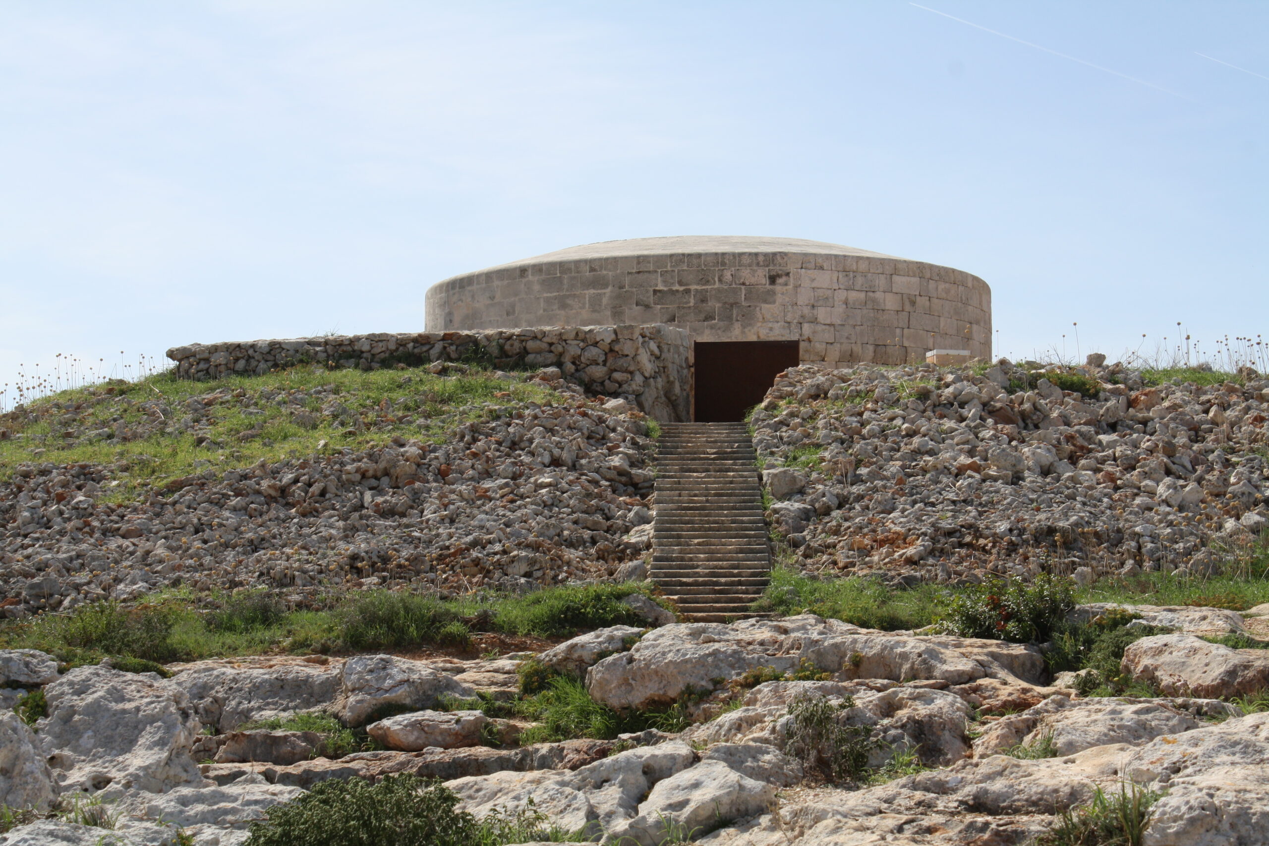 Cala Santandría Menorca: de beschutte kreek bij Ciutadella en de Torre des Castellar 5 De Torre des Castellar verzonken achter zijn wal, met de trap die naar de ingang onder het maaiveld voert