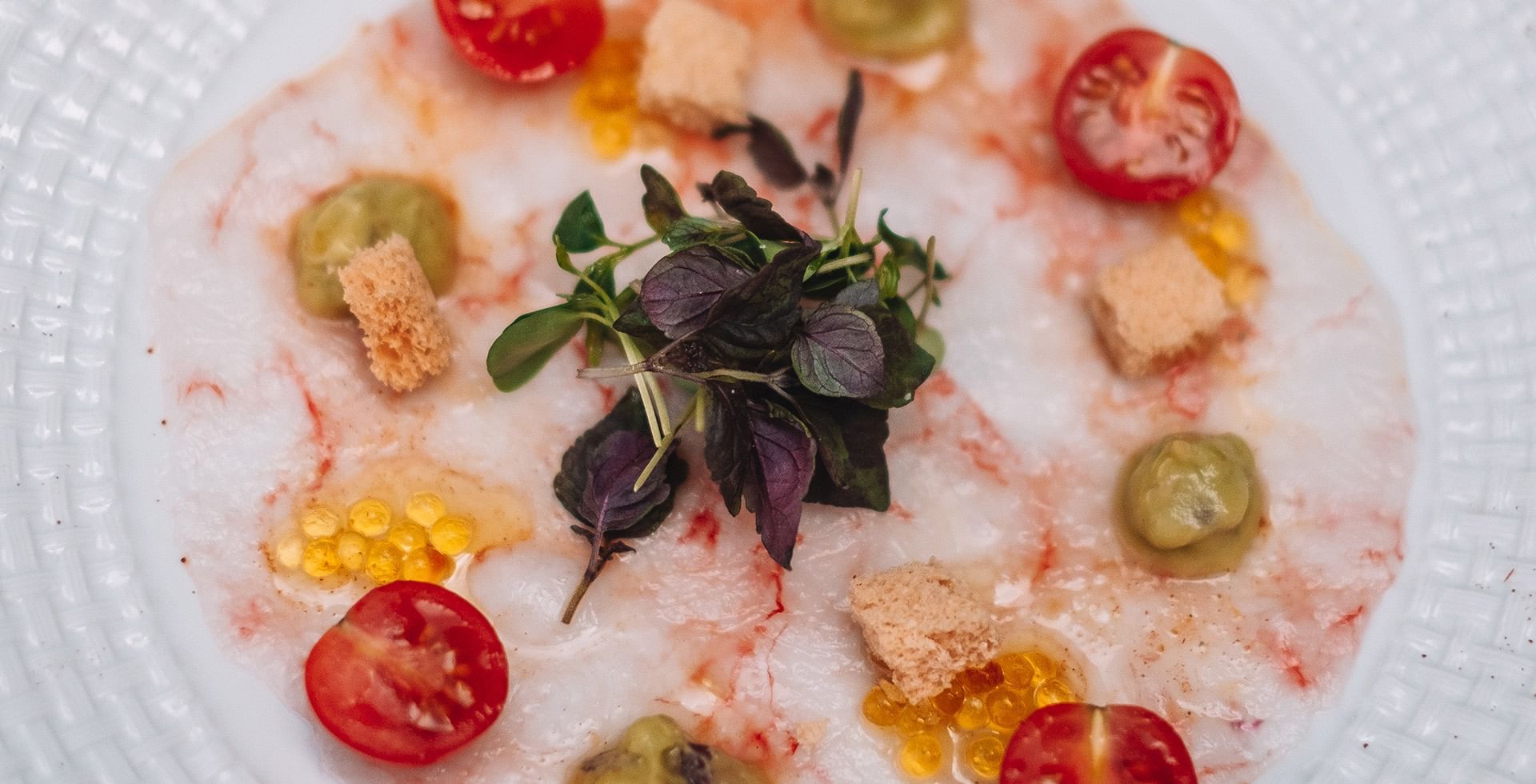 Ca'n Blau Sóller: het restaurant van het Gran Hotel uit 1880 2 Carpaccio van rode garnaal bij Ca'n Blau in Sóller, met tomaatjes, kruiden en krokante stukjes op een wit bord