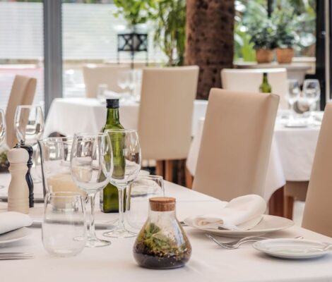 De eetzaal van restaurant Ca'n Blau in het Gran Hotel Sóller, met wit gedekte tafels, lichte stoelen en hoge ramen