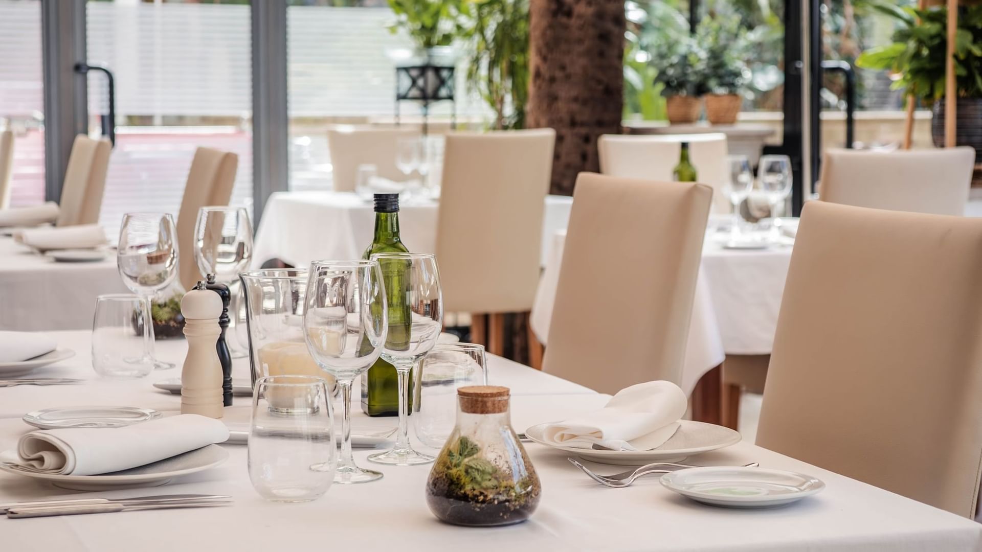 Ca'n Blau Sóller: het restaurant van het Gran Hotel uit 1880 1 De eetzaal van restaurant Ca'n Blau in het Gran Hotel Sóller, met wit gedekte tafels, lichte stoelen en hoge ramen