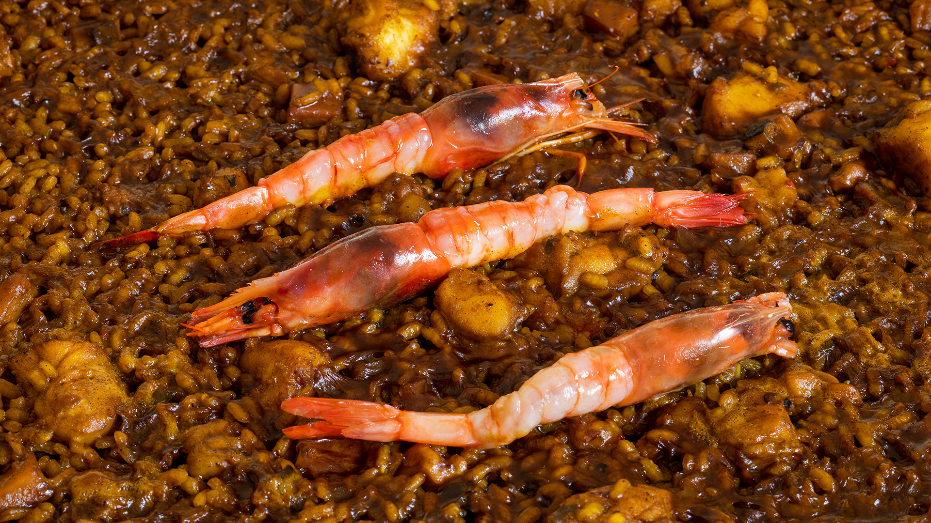 Rijstgerecht met drie grote garnalen in de pan bij Can Rafalet