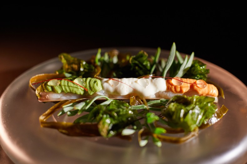 Can Simoneta Gastronòmic (Canyamel): Mexicaans-Mallorcaans menu op de klif 2 Gerecht van Can Simoneta Gastronomic met zeevruchten in de schelp, zeewier, kruiden en een romige saus op een koperkleurig bord