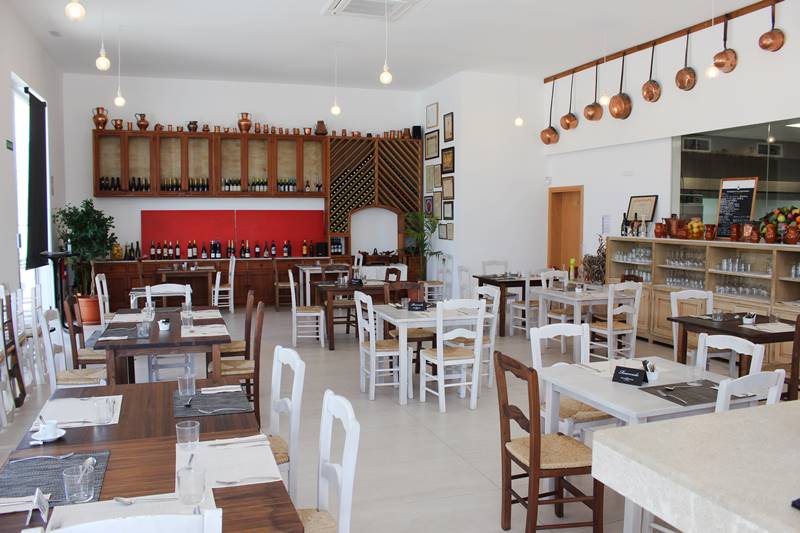De verdwijnende cellers van Mallorca: het pand is beschermd, de zaak niet 3 De lichte eetzaal van Can Amer in Lloseta met witte stoelen, gedekte tafels en een rij koperen pannen aan de muur
