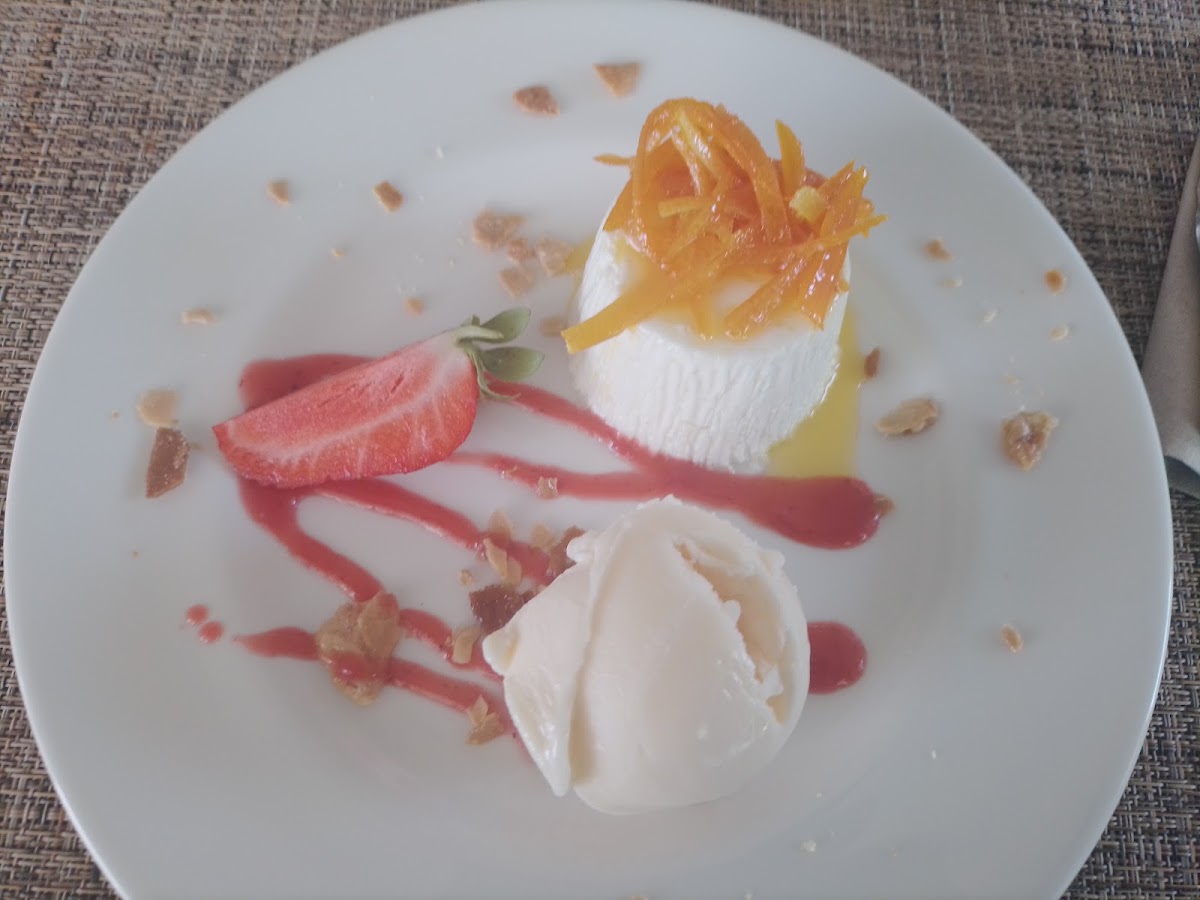 Celler Can Amer: van het oude celler in Inca naar Lloseta 7 Nagerecht van room en sorbet met gekonfijte sinaasappelschil en een aardbei op een wit bord bij Can Amer