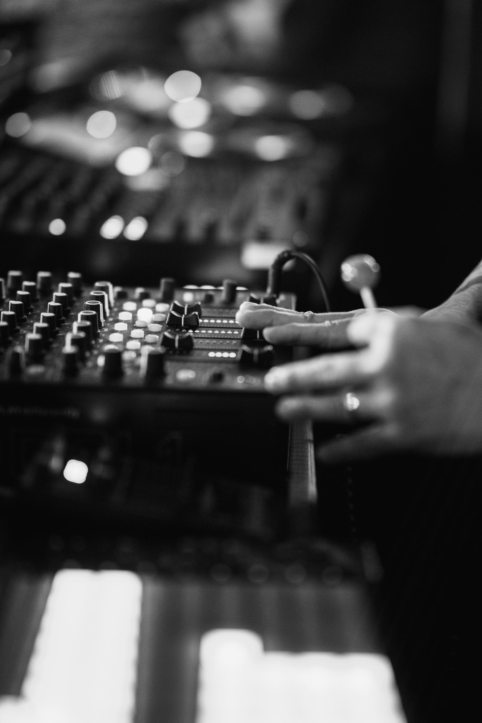 Handen op het mengpaneel in de dj-booth van Chinois Ibiza, in zwart-wit
