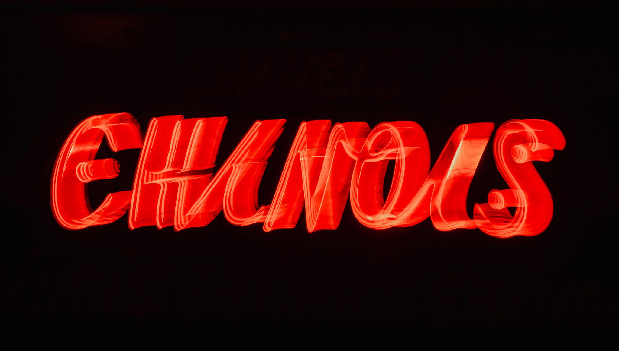 Het rode neonbord met de naam Chinois in de donkere zaal van de club op Ibiza