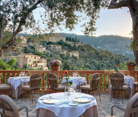 El Olivo (Deià, Mallorca): proefmenu in de oude olijfmolen van La Residencia 7 Het terras van restaurant El Olivo in Deia met gedekte tafels onder oude olijfbomen en uitzicht op het dorp en de Tramuntana