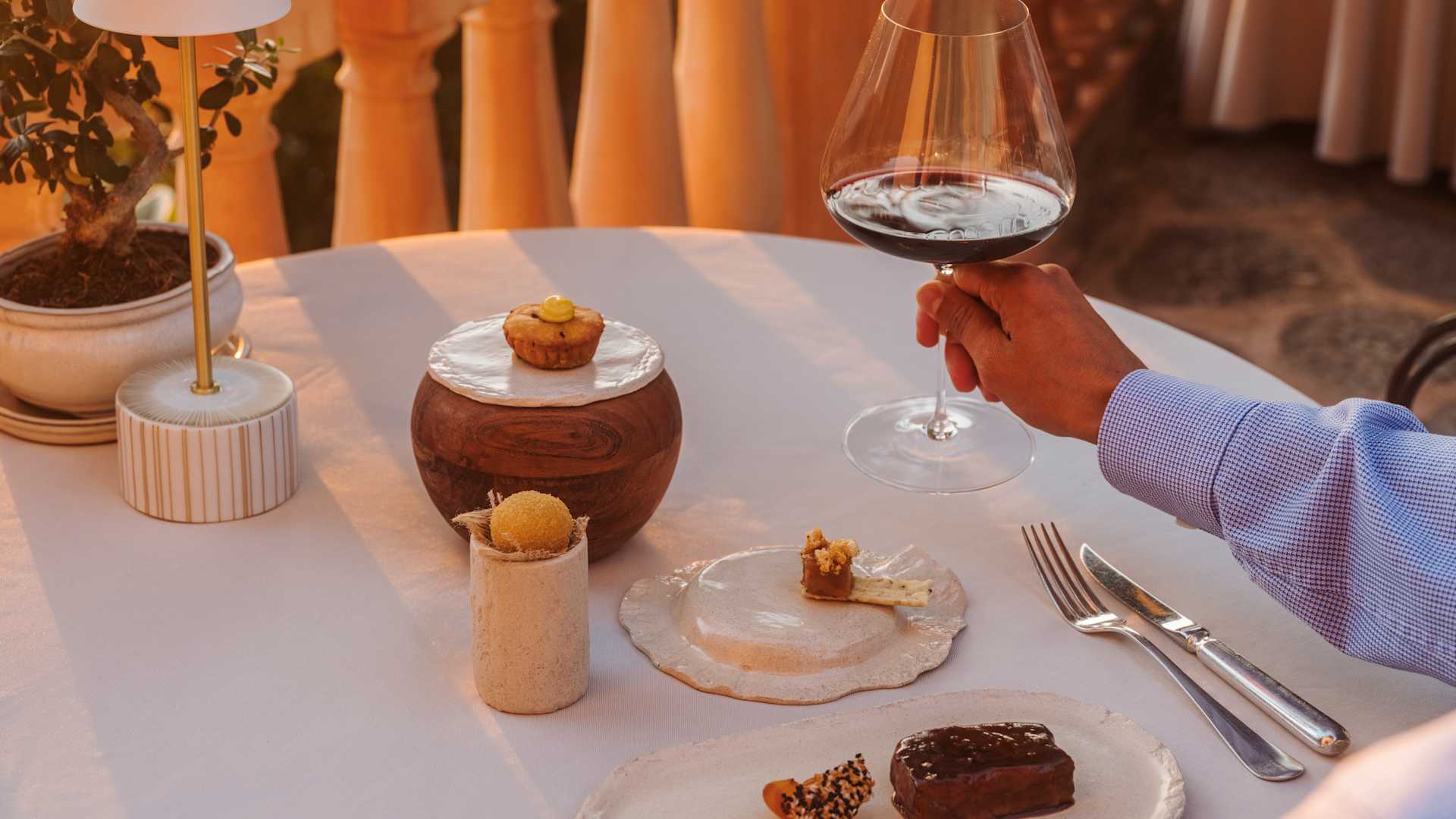 Zoetigheden aan het eind van het menu van El Olivo op het terras, met een glas rode wijn in de avondzon