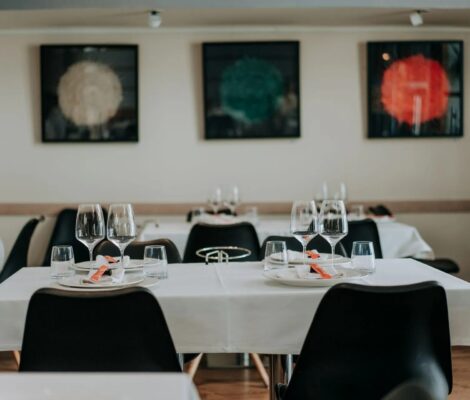 Emilio Innobar in Palma: fine fusion van Japan, Mexico en Mallorca 4 De eetzaal van Emilio Innobar in Palma met gedekte tafels met witte kleden, zwarte stoelen en drie moderne schilderijen aan de muur