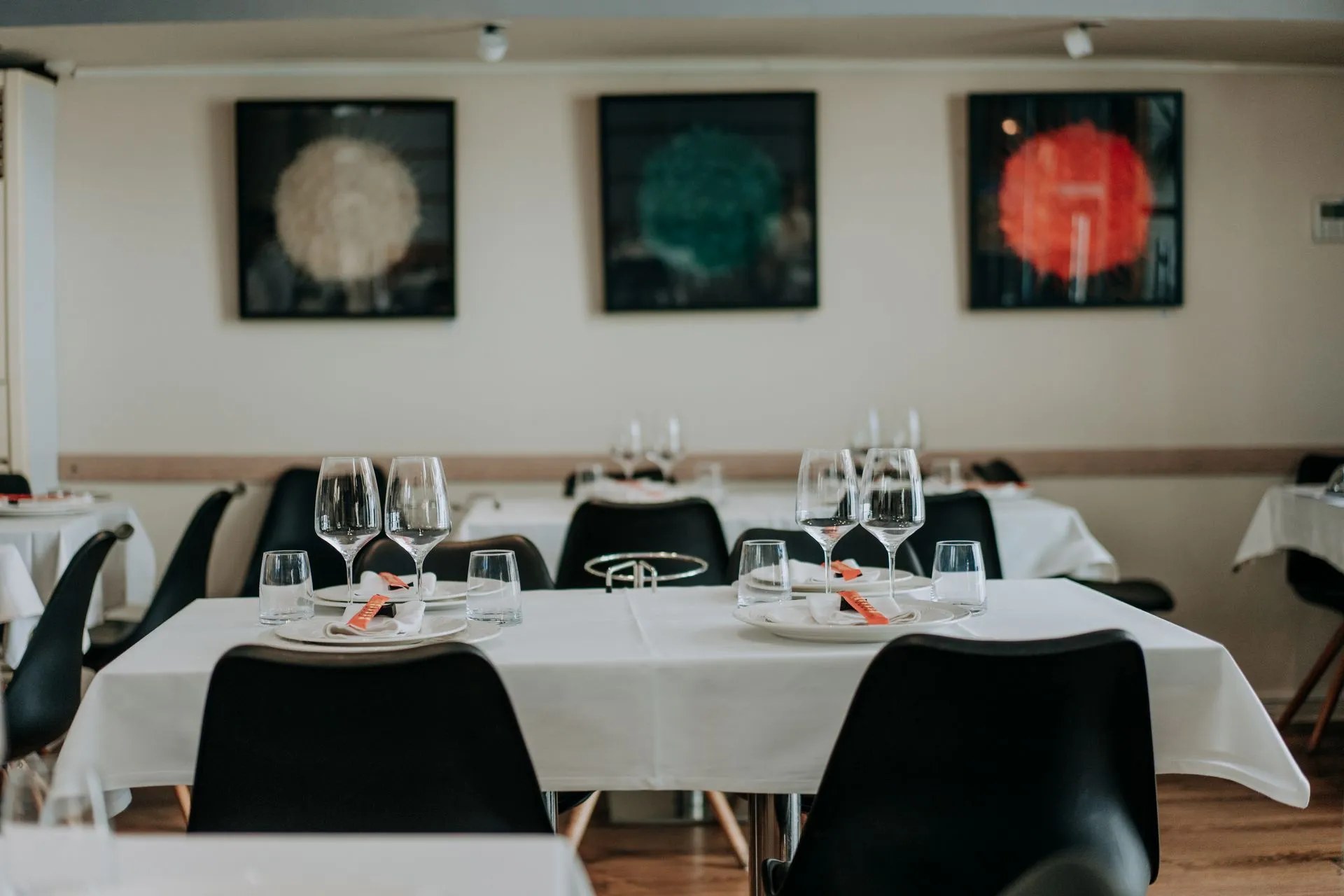 Emilio Innobar in Palma: fine fusion van Japan, Mexico en Mallorca 1 De eetzaal van Emilio Innobar in Palma met gedekte tafels met witte kleden, zwarte stoelen en drie moderne schilderijen aan de muur