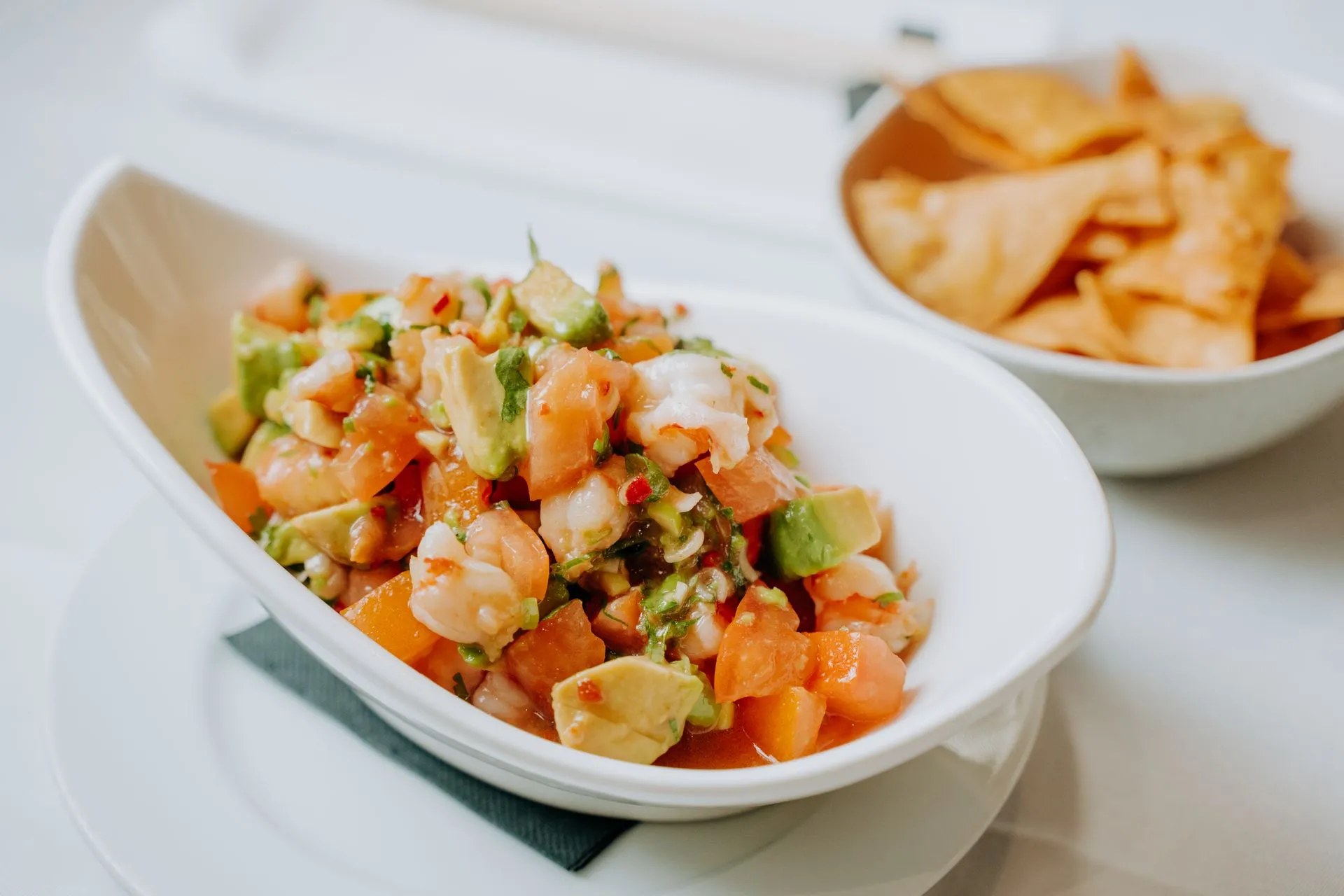 Emilio Innobar in Palma: fine fusion van Japan, Mexico en Mallorca 4 Ceviche met gamba, avocado en tomaat in een langwerpige schaal, met een kommetje tortillachips ernaast