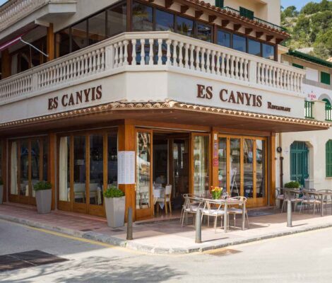 De gevel van restaurant Es Canyís op de hoek van de boulevard in Port de Sóller, met houten pui en de naam in gouden letters
