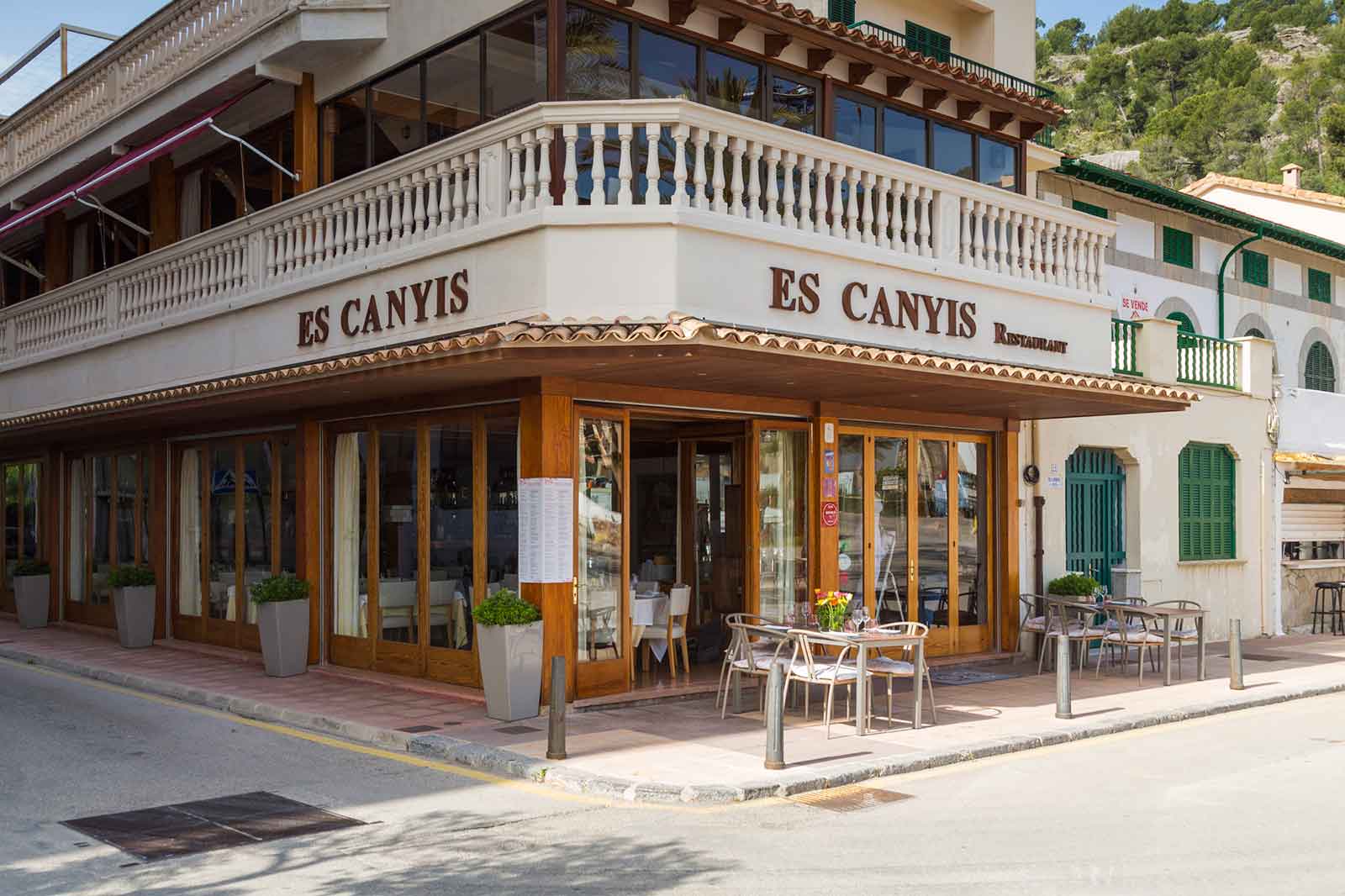 De gevel van restaurant Es Canyís op de hoek van de boulevard in Port de Sóller, met houten pui en de naam in gouden letters