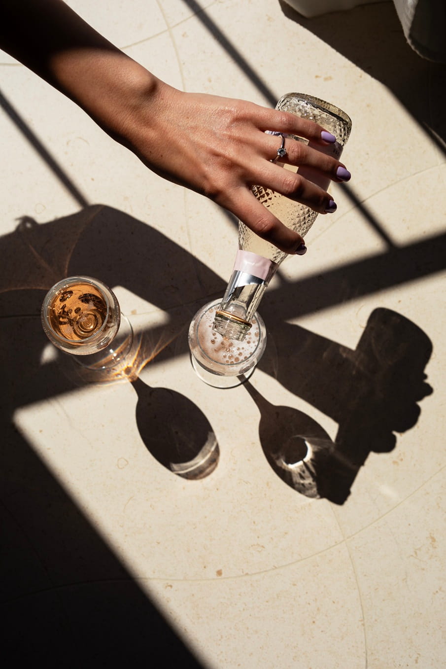 Rosewijn wordt ingeschonken in twee glazen op een stenen tafel in het zonlicht bij Es Marès
