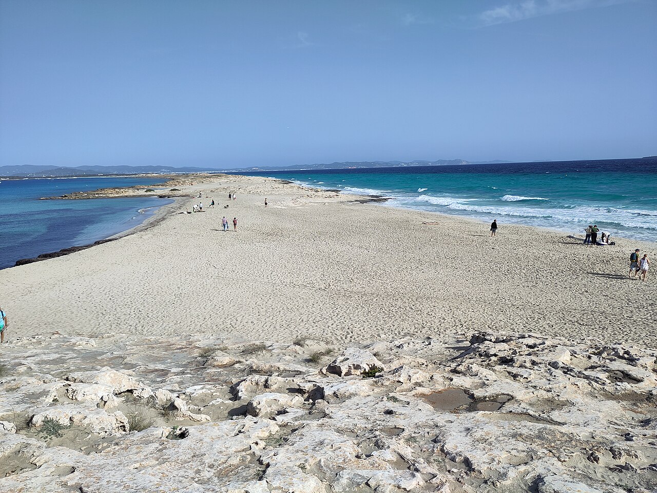 Es Trucadors Formentera: de landtong met zee aan twee kanten 1 De zandlandtong van Es Trucadors op Formentera met rustig water links en branding rechts, en Ibiza aan de horizon