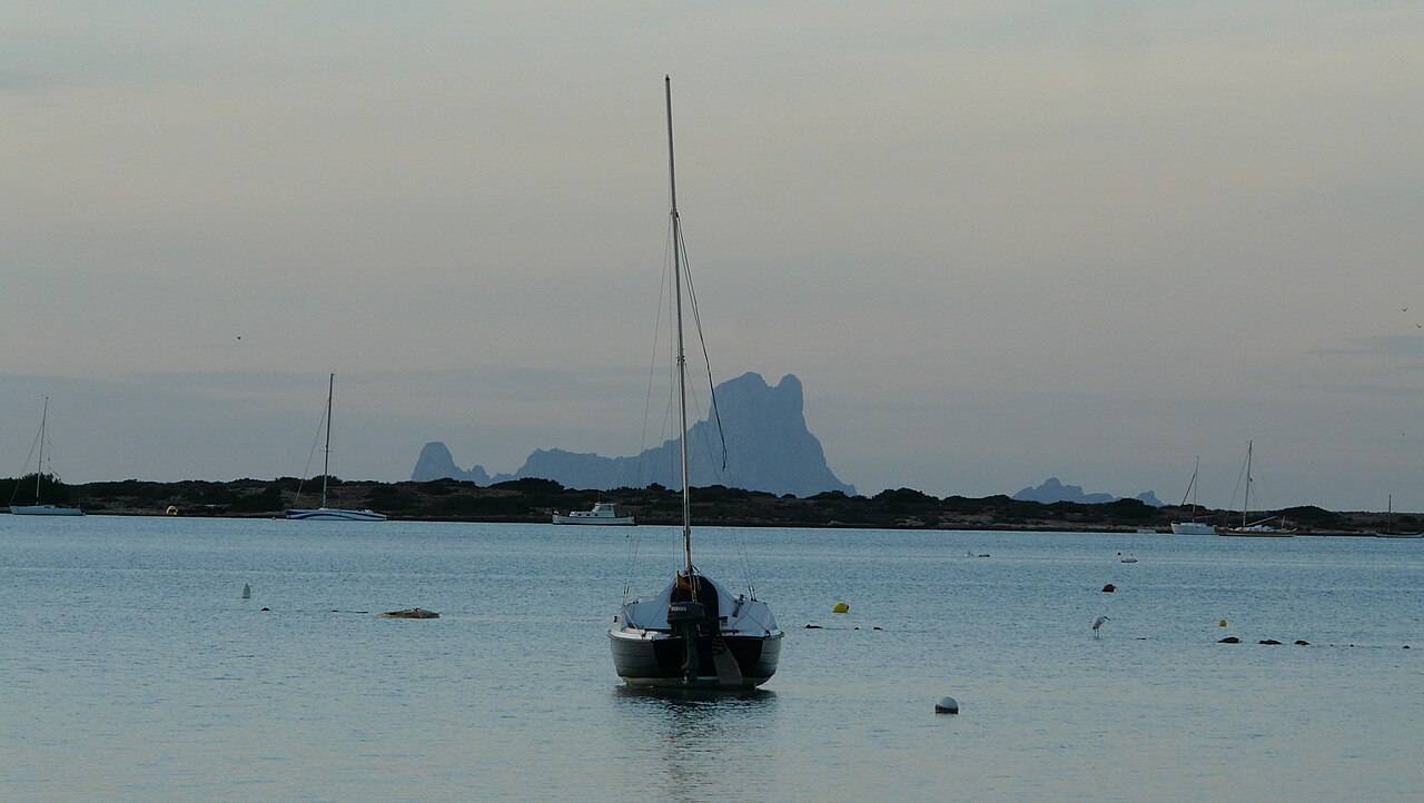 Estany des Peix Formentera: de lagune naast de haven van La Savina 5 Bootje op een boei in de Estany des Peix met Es Vedra achter de duinrug aan de horizon