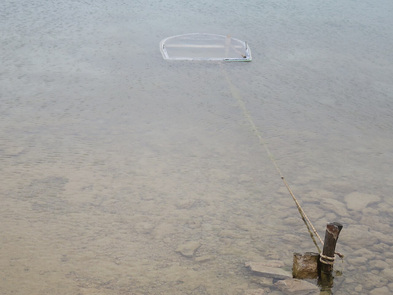 Estany des Peix Formentera: de lagune naast de haven van La Savina 4 Een gezonken bootje in het heldere ondiepe water van de Estany des Peix, nog vast aan zijn meerpaal