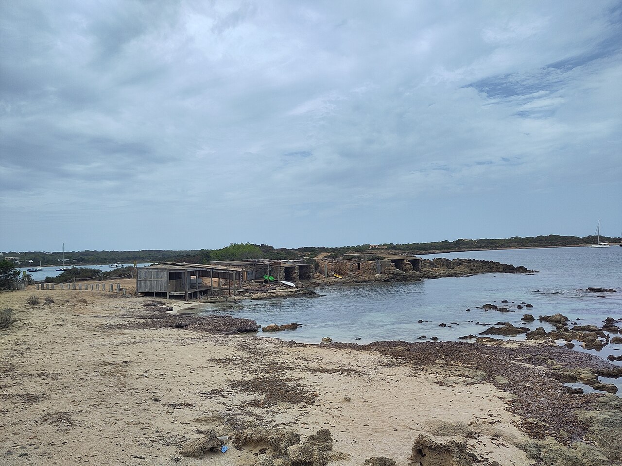 Estany des Peix Formentera: de lagune naast de haven van La Savina 6 Rij oude botenhuizen van steen en hout aan de rotsige westoever van de Estany des Peix bij Caló de l'Oli