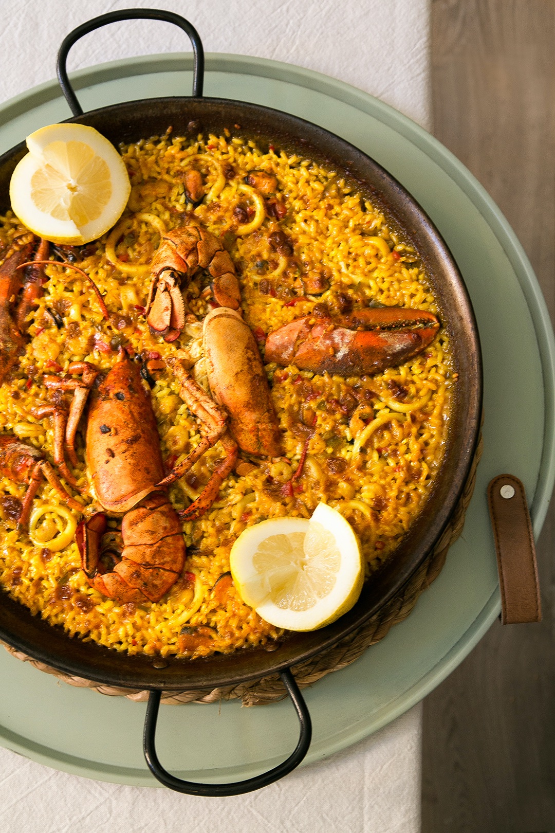 Fervor Palma: eten in een oude kantine uit 1890 2 Paella met garnalen, langoustines en partjes citroen in een pan op tafel bij restaurant Fervor in Palma