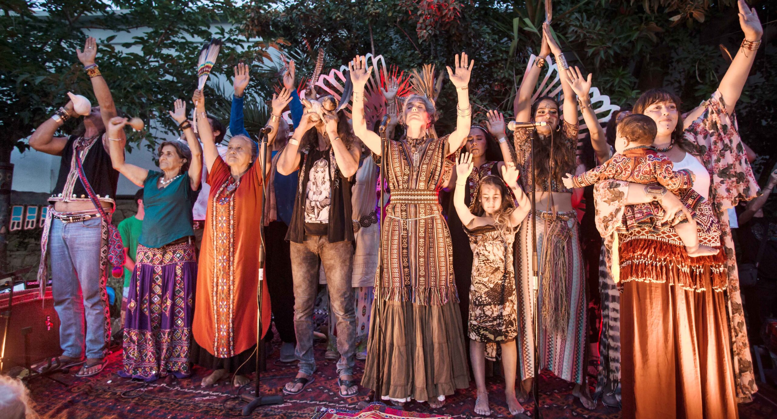 Ibiza in juni: weer, zeewater en de vuren van Sant Joan 1 Optreden met opgeheven handen op het podium van de hippiemarkt Las Dalias op Ibiza in de avond