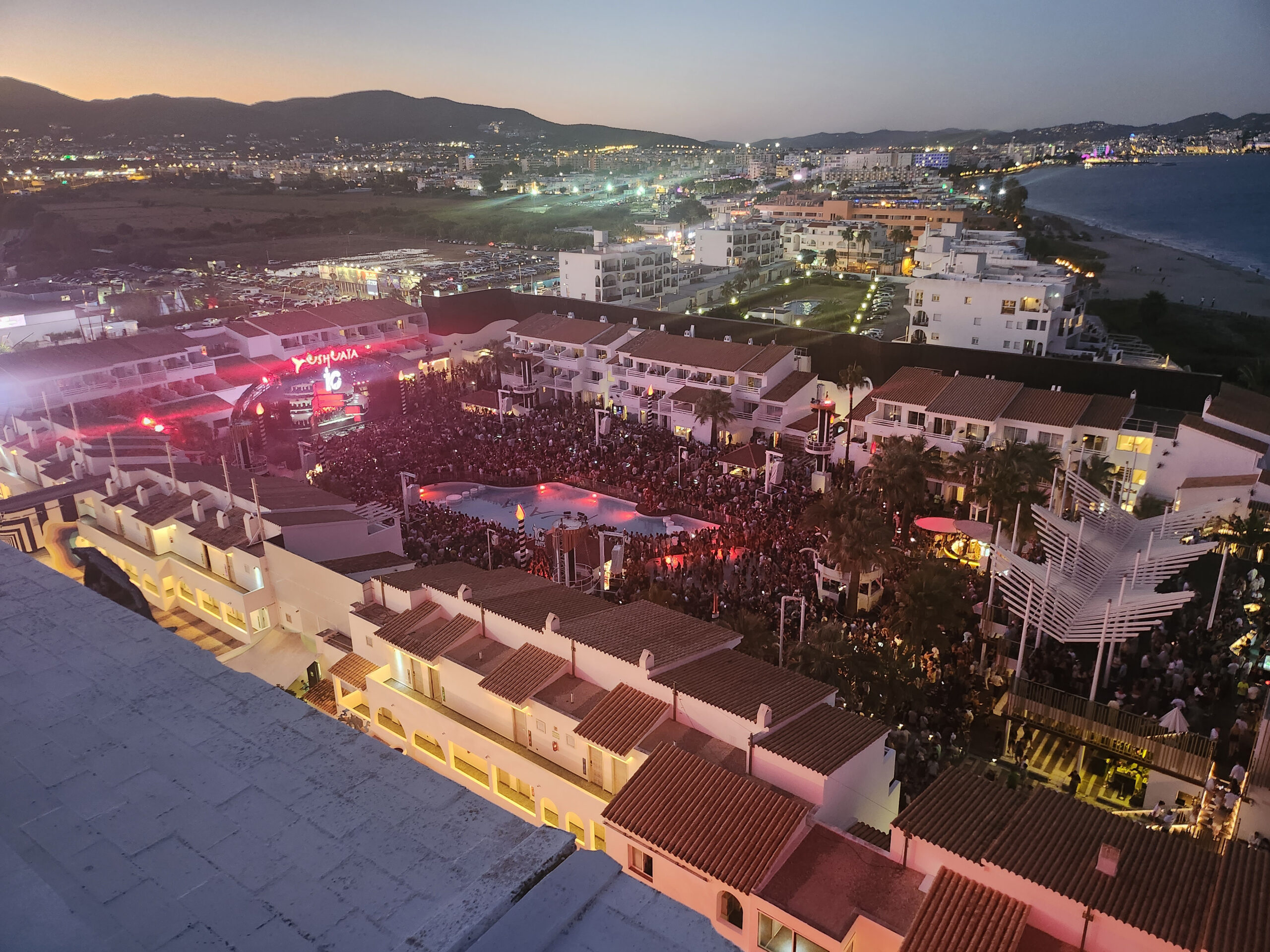 Ibiza in september: het warmste zeewater en minder drukte 2 Volle dansvloer en zwembad van club Ushuaia aan Playa d en Bossa op Ibiza in het avondlicht