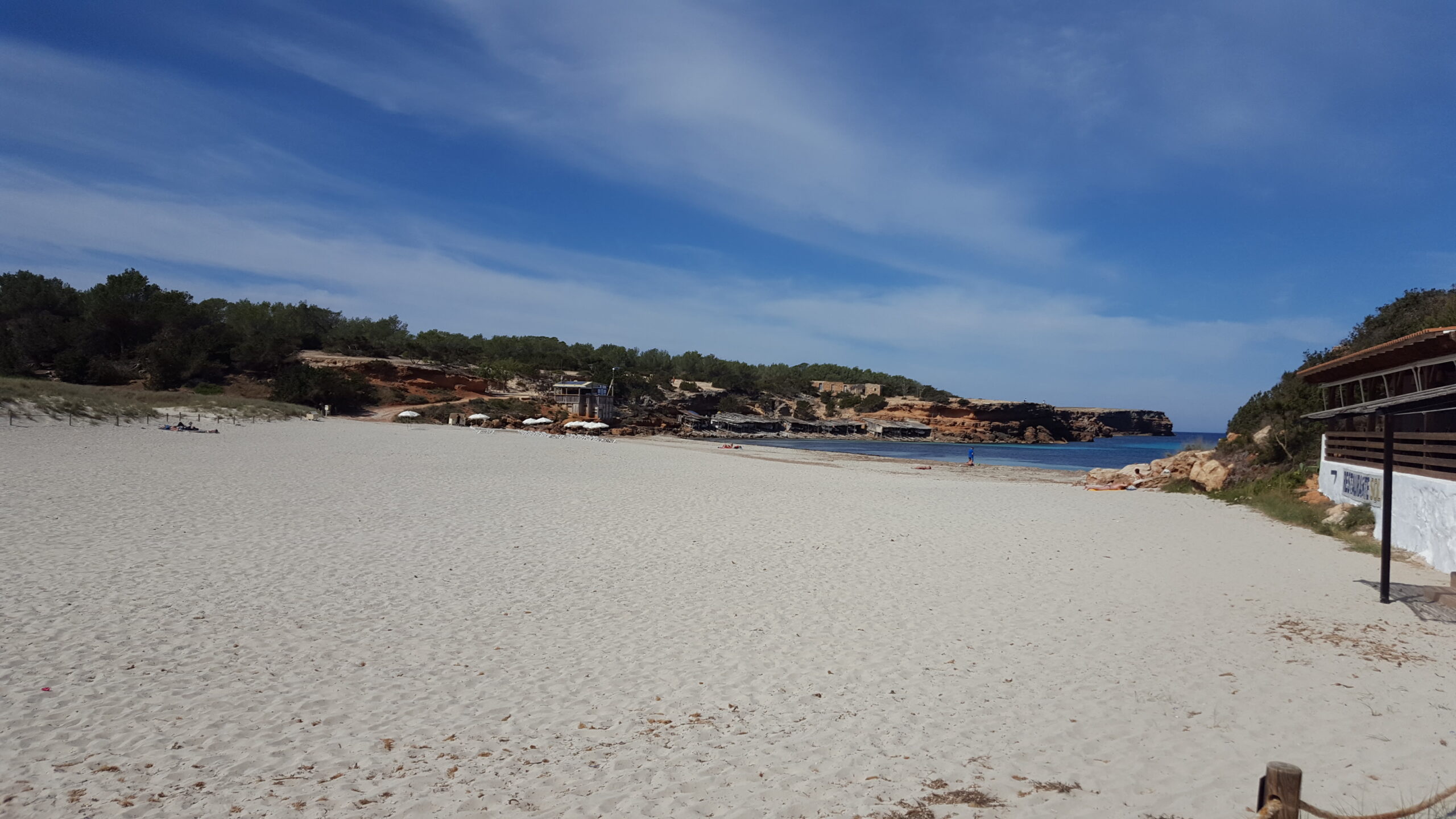 Kwallen op Formentera: welke kust, vlag en eerste hulp 2 De naar het westen gekeerde baai van Cala Saona op Formentera, met zand tussen twee lage rotspunten