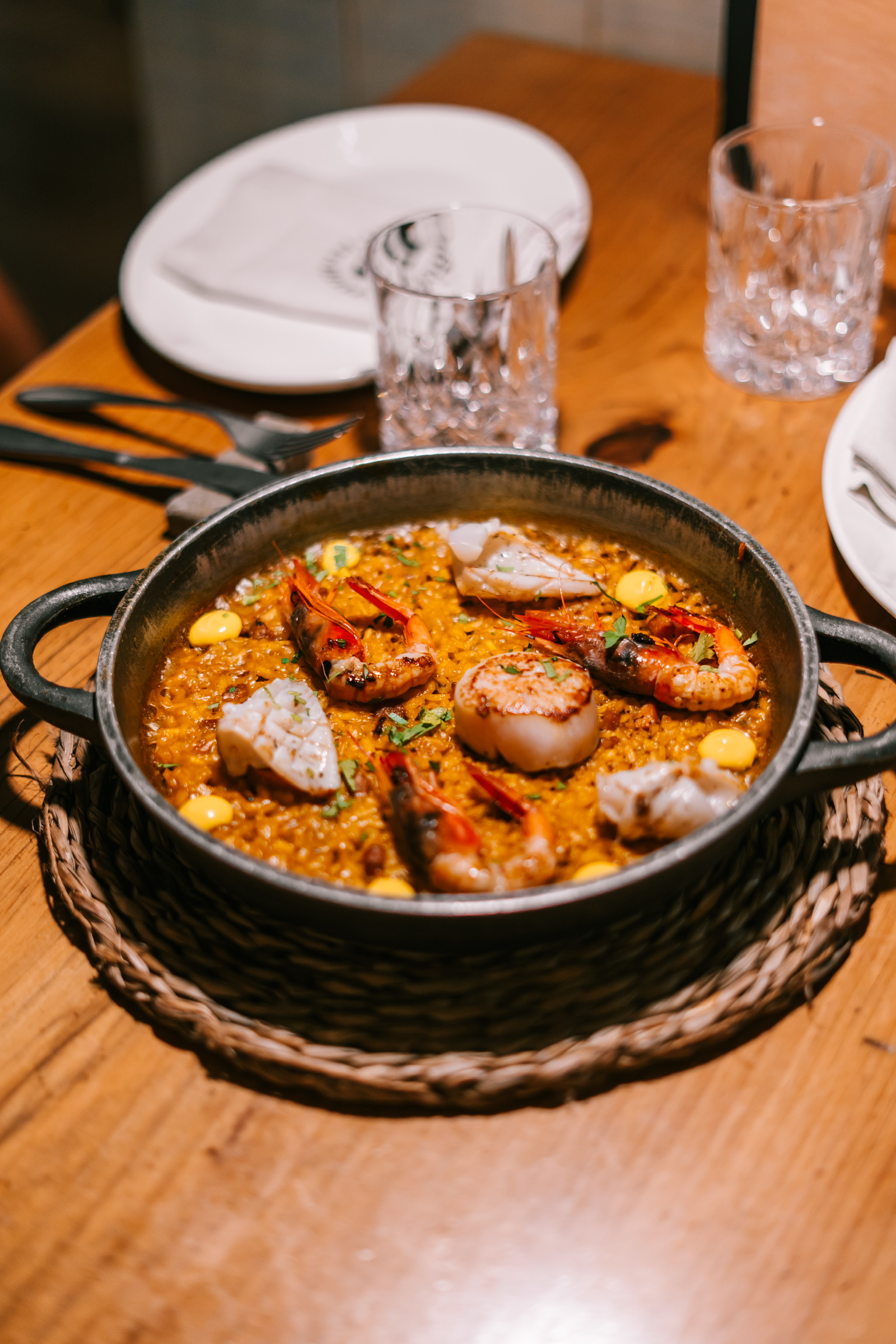 Pan met rijst, rode garnalen en sint-jakobsschelpen op de houten tafel van restaurant La Bodeguilla in Palma