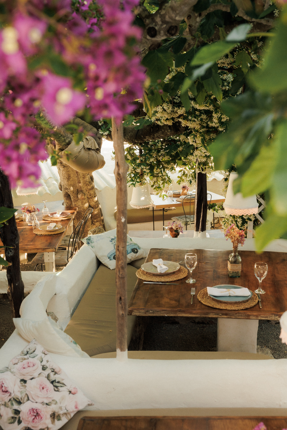 La Luna nell’Orto Ibiza: zelfgemaakte pasta onder een eeuwenoude vijgenboom 5 Gedekte tafels op het terras van La Luna nell’Orto onder bloeiende bougainville en jasmijn, met raffia placemats