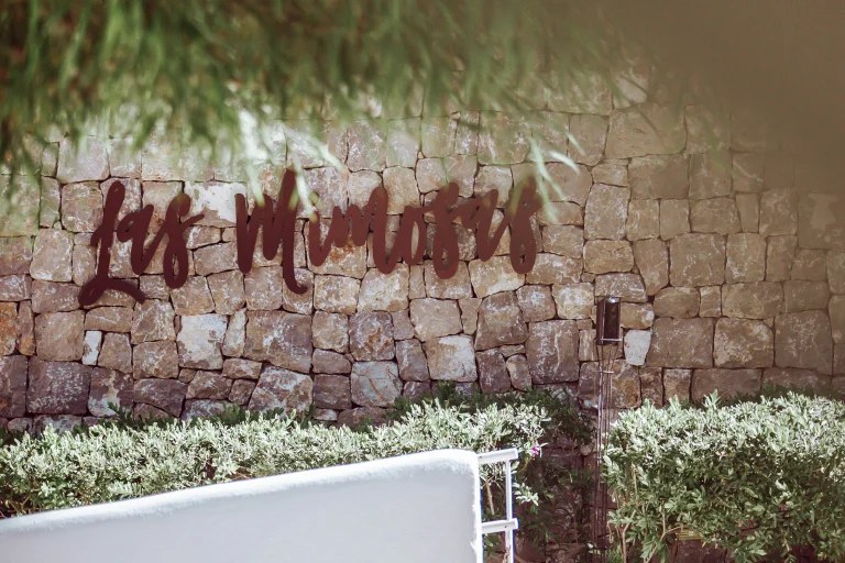 Las Mimosas Ibiza: boutiquehotel met zeventien suites bij Sant Antoni 4 Het naambord van Las Mimosas in een muur van natuursteen