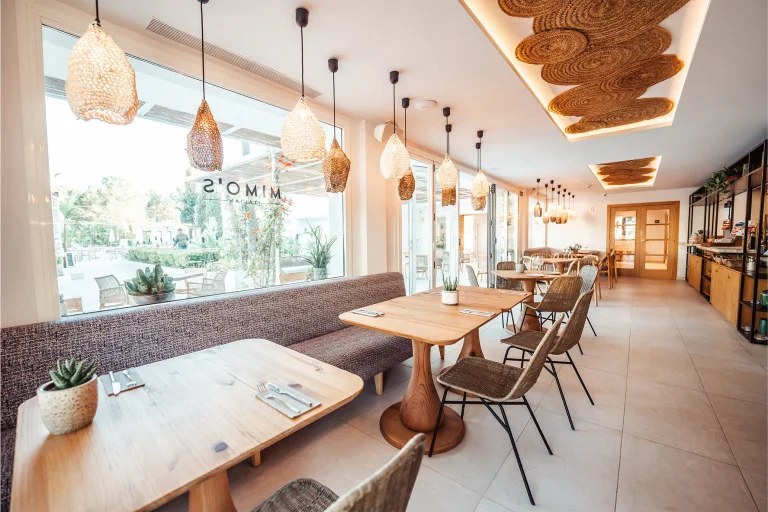 Las Mimosas Ibiza: boutiquehotel met zeventien suites bij Sant Antoni 3 Het interieur van restaurant Mimo's met lange tafels en rieten lampen