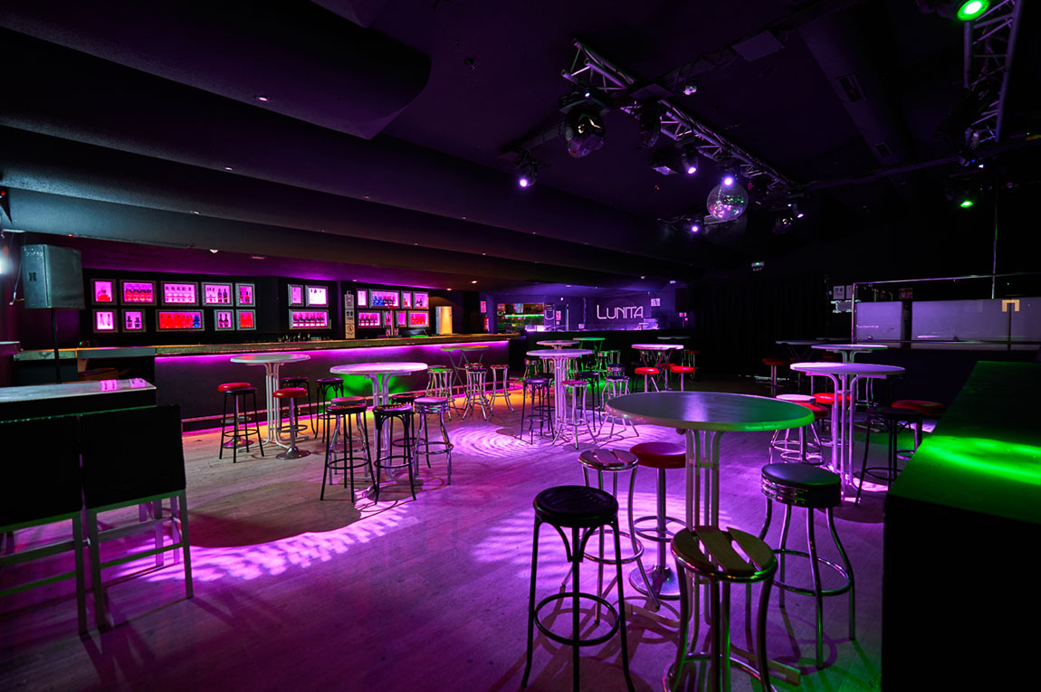 Lunita Can Pastilla: de technoclub met zwembad bij Playa de Palma 2 De binnenzaal van Lunita in Can Pastilla met de lange bar, statafels en krukken in paars licht