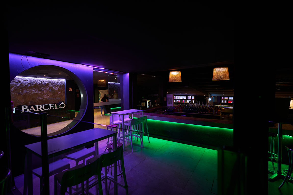 Lunita Can Pastilla: de technoclub met zwembad bij Playa de Palma 6 Een hoek van de zaal van Lunita in Can Pastilla met statafels en groene ledverlichting onder de bar