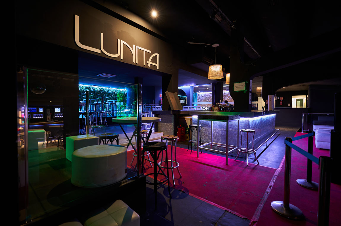 Lunita Can Pastilla: de technoclub met zwembad bij Playa de Palma 1 De bar van club Lunita in Can Pastilla met het verlichte logo boven de tap en roze vloerverlichting