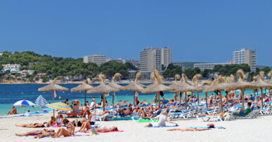 Mallorca in juli: hitte, droogte en waar het koeler is 6 Het strand van Magaluf op Mallorca met badgasten, parasols en turquoise water op een julidag