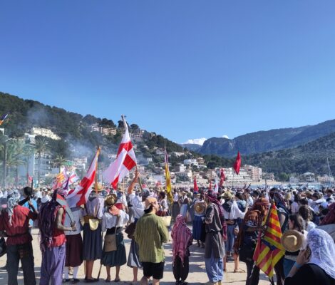 Verklede deelnemers met vlaggen op de kade van Port de Sóller tijdens Es Firó