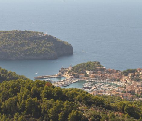 Uitzicht vanaf Mirador de ses Barques op de baai en jachthaven van Port de Sóller, met de vuurtoren op het beboste schiereiland links en de zee erachter