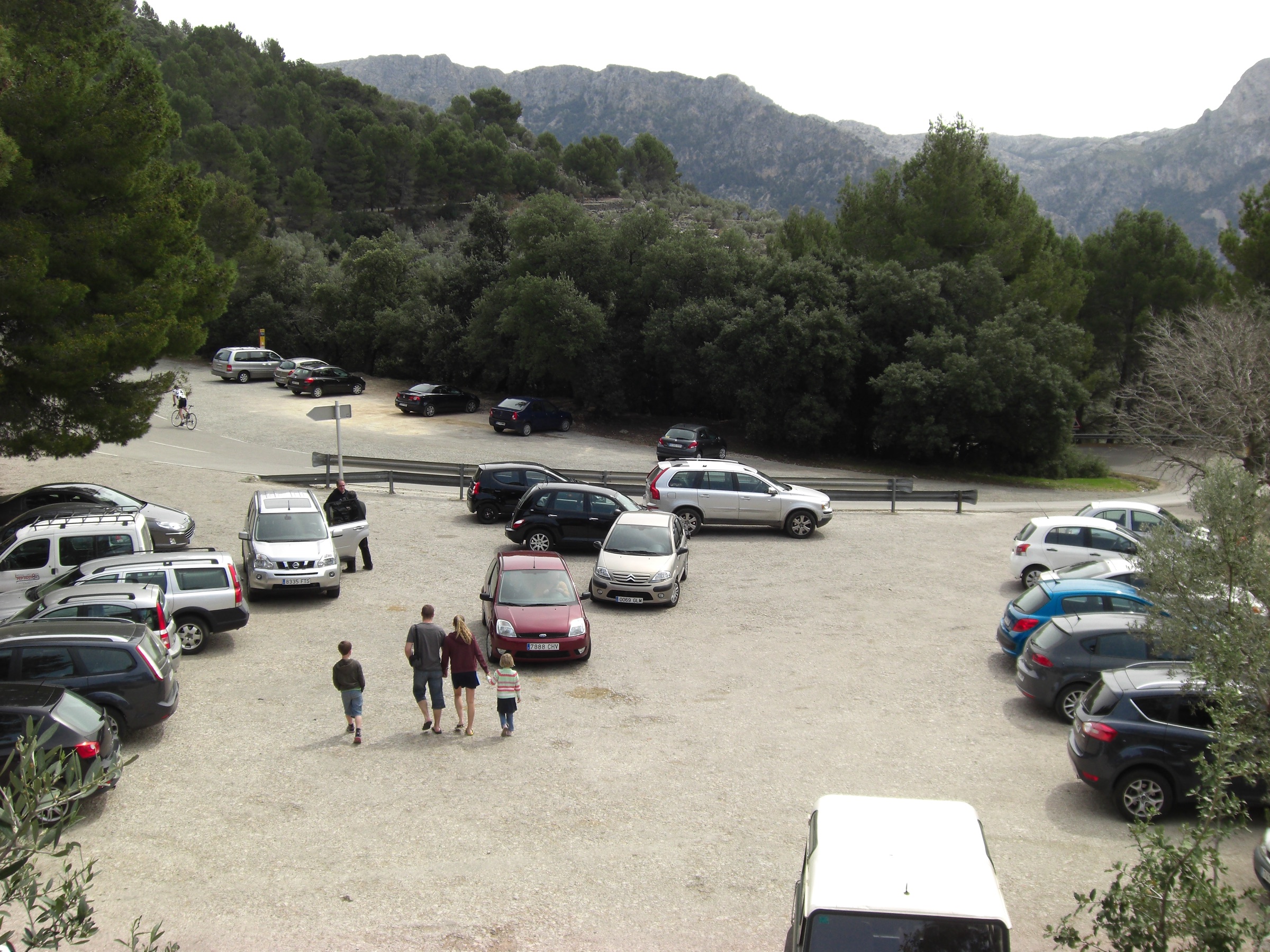 Mirador de ses Barques: het uitzichtpunt boven Port de Sóller 7 Het parkeerterrein bij Mirador de ses Barques aan de Ma-10, met tientallen geparkeerde auto's, bezoekers die naar het uitzichtpunt lopen en de bergen van de Tramuntana erachter
