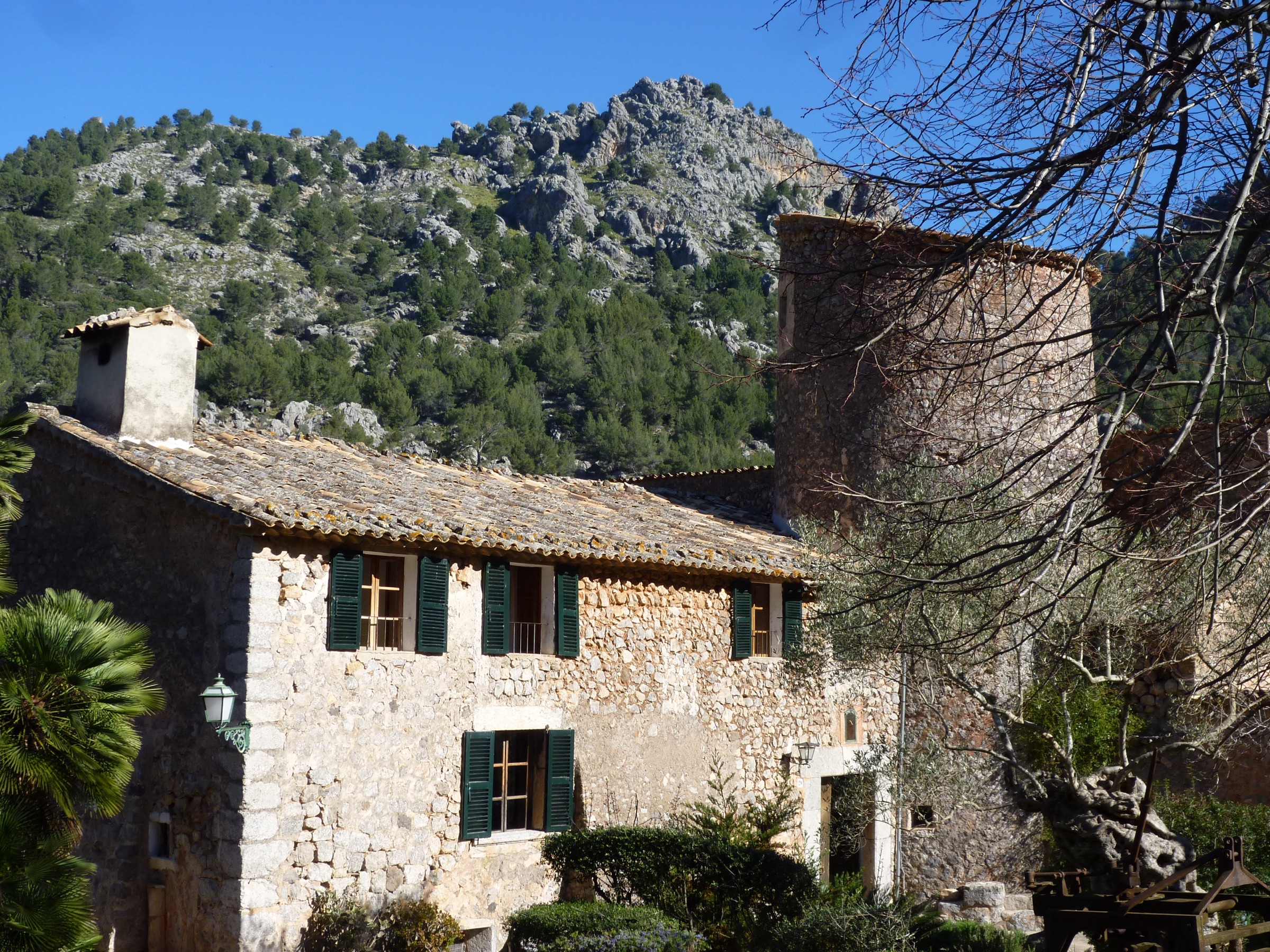 Mirador de ses Barques: het uitzichtpunt boven Port de Sóller 6 Het stenen landgoed Bàlitx d'Avall met groene luiken en een vierkante toren, onder een rotsige bergkam in het dal van Bàlitx