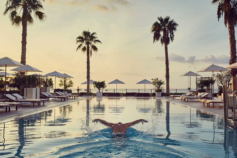 Nobu Hotel Ibiza Bay: het strandhotel van Talamanca 6 Zwemmer in het zwembad van Nobu Hotel Ibiza Bay bij zonsondergang