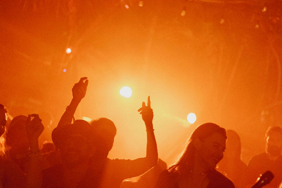 Silhouetten van gasten tegen de ondergaande zon bij Nômade Temple Ibiza