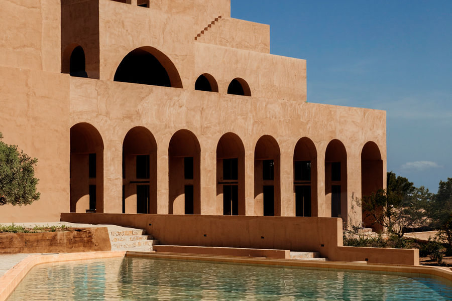 Het hoofdgebouw van Nômade Temple Ibiza met bogenrij en zwembad