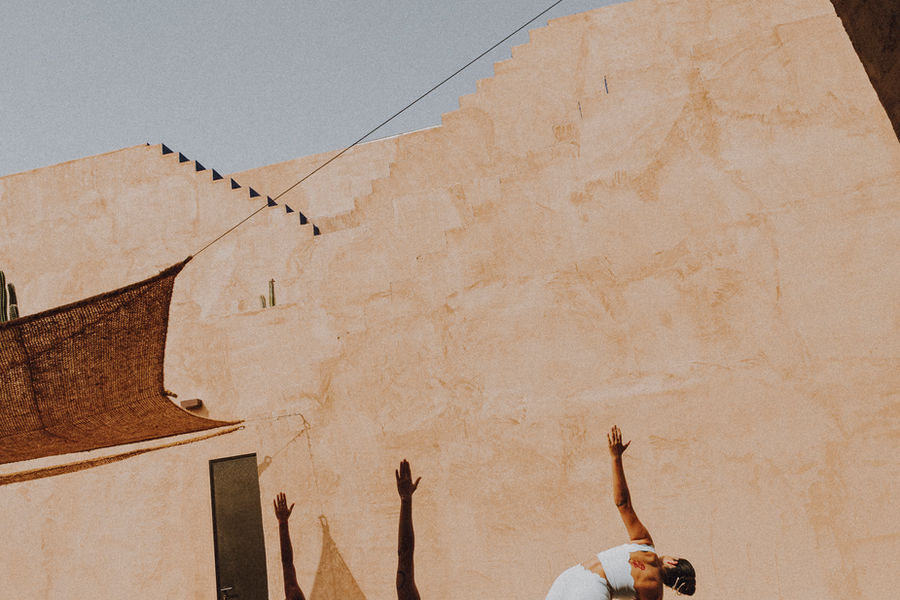 Yogasessie tegen de terracottakleurige muur van Nômade Temple Ibiza
