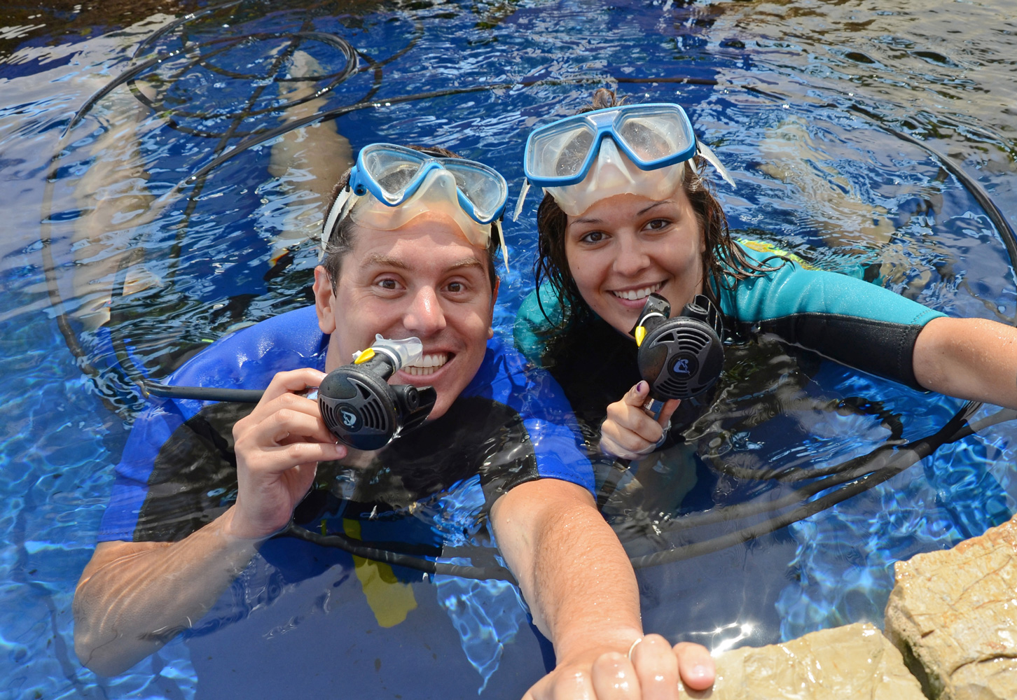 Twee duikers met masker en ademautomaat aan het wateroppervlak van het haaienbassin van Palma Aquarium