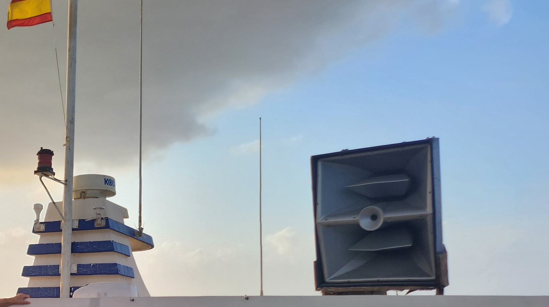 Partyboot Ibiza: prijzen, open bar, havens en de eerlijke nadelen 3 Grote hoornluidspreker en Spaanse vlag op het dak van een partyboot op Ibiza