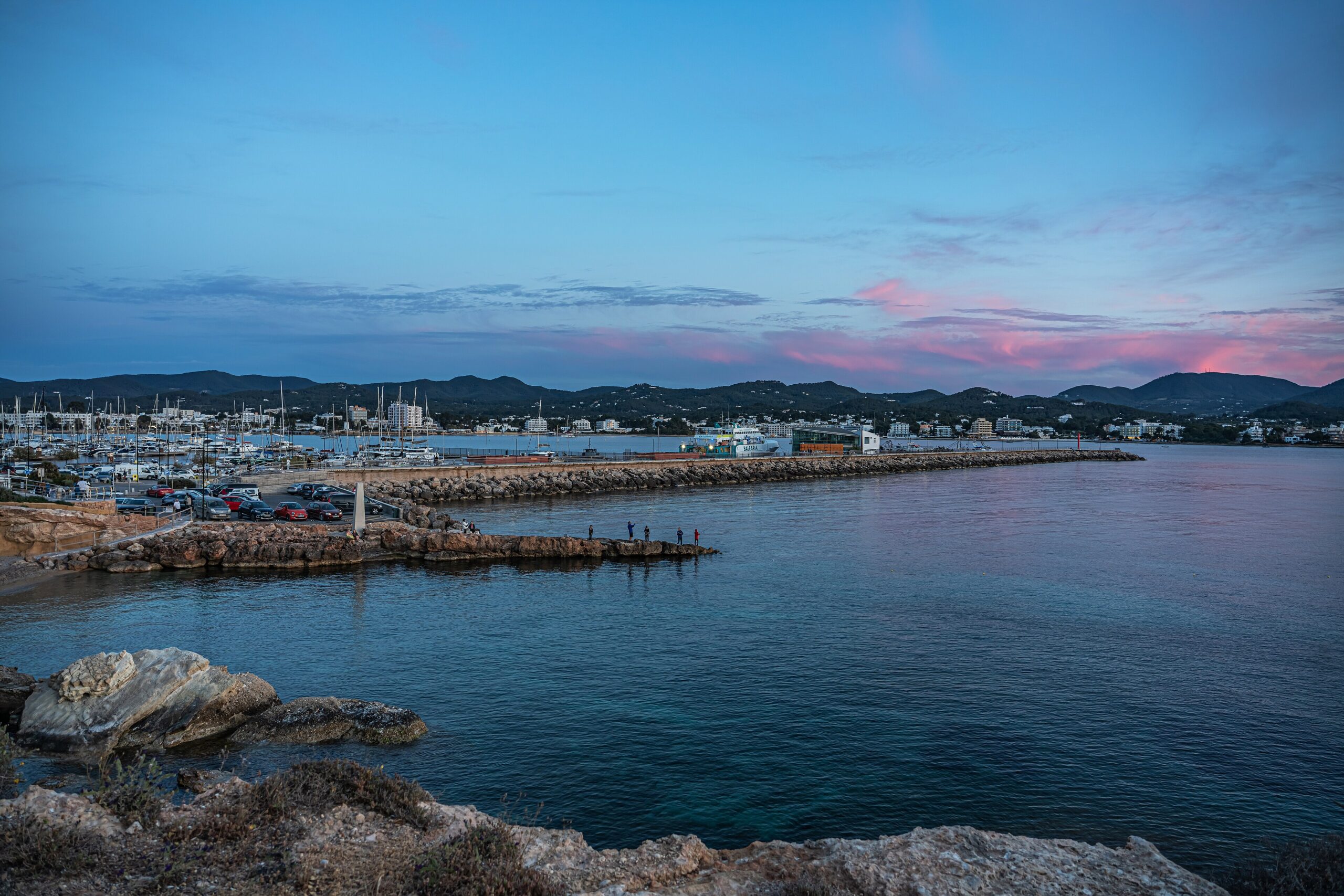 Partyboot Ibiza: prijzen, open bar, havens en de eerlijke nadelen 4 De haven van Sant Antoni de Portmany op Ibiza in de schemering, met de havendam en de jachthaven