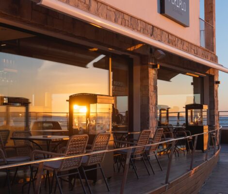 Periplo Portixol (Palma): vis van de grill aan het water in es Molinar 10 De gevel en het houten terras van restaurant Periplo Portixol in Palma bij zonsondergang, met de zee achter de open ramen
