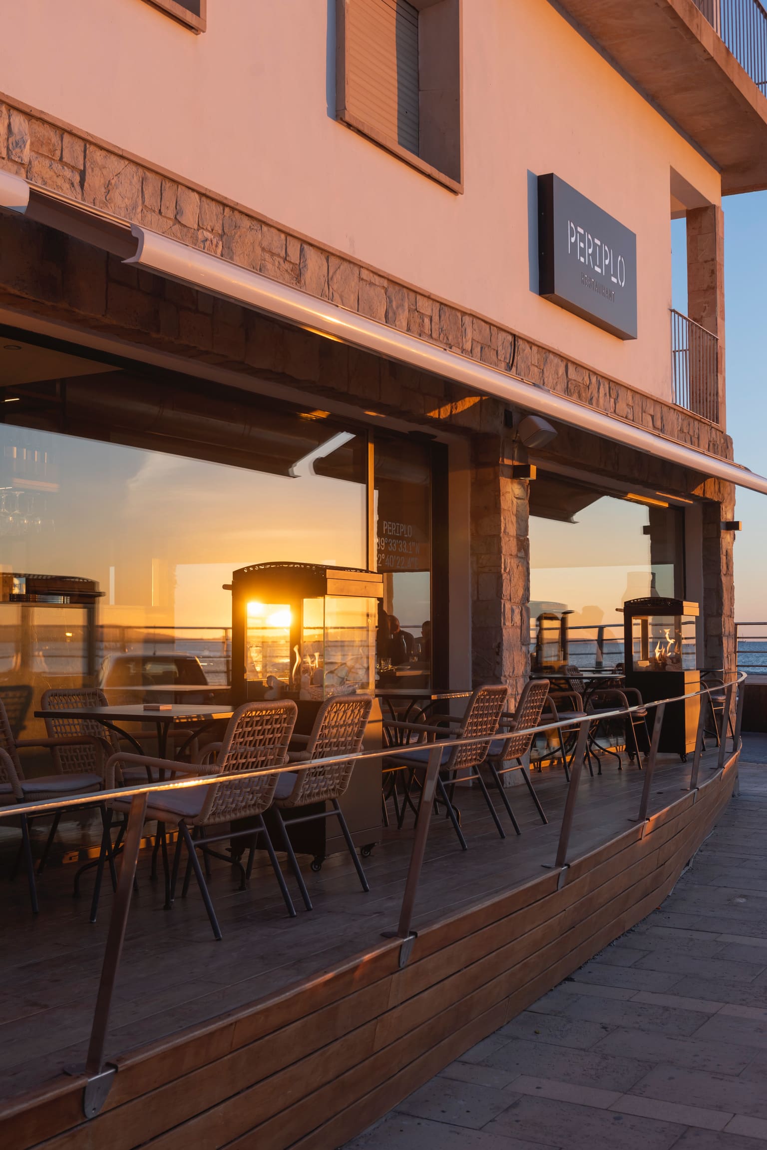 Periplo Portixol (Palma): vis van de grill aan het water in es Molinar 1 De gevel en het houten terras van restaurant Periplo Portixol in Palma bij zonsondergang, met de zee achter de open ramen